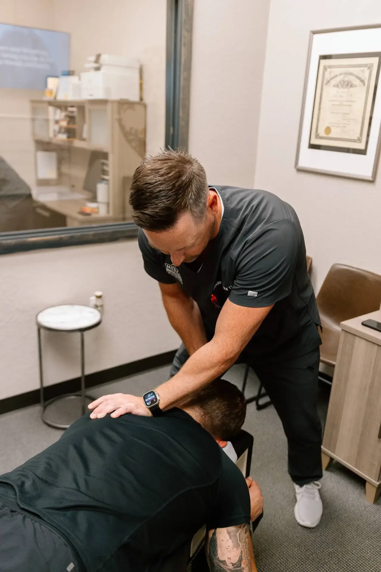 Chiropractor treating patient with shoulder adjustment